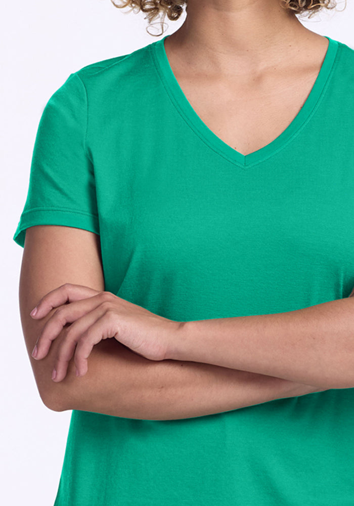 Person wears the Woolx Junie V Neck - Jungle, standing with arms crossed, shown from shoulders to waist.