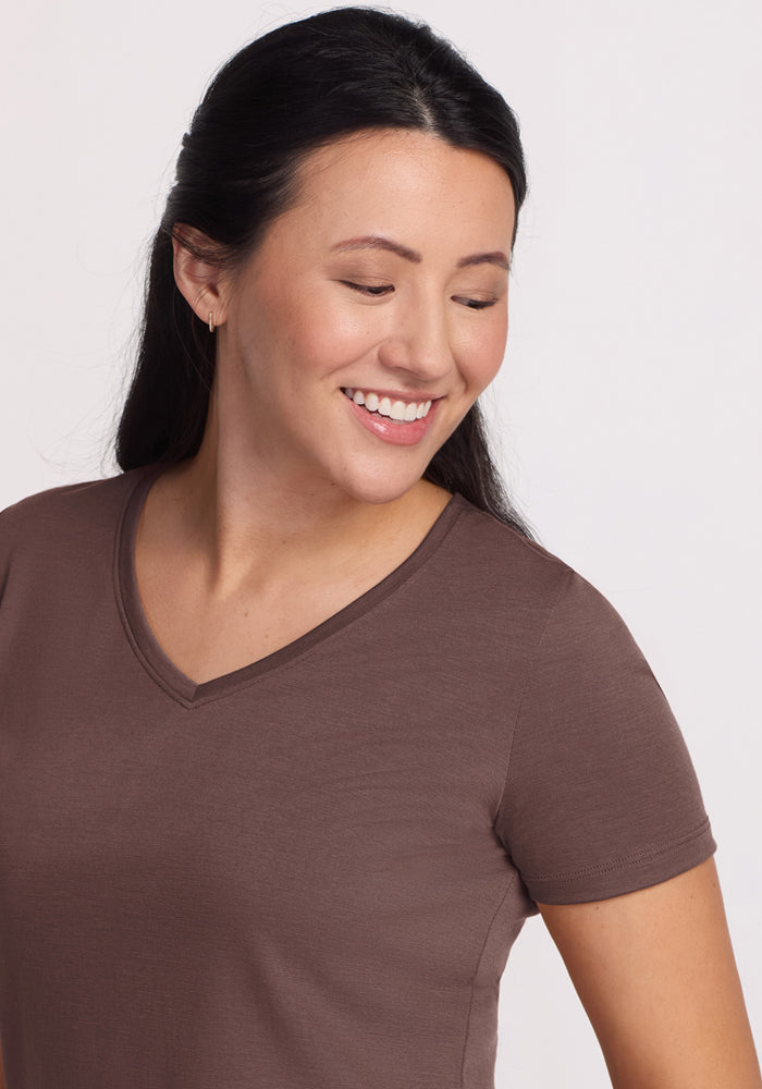 Smiling woman with long dark hair wears the Woolx Junie V Neck in Peppercorn, known for moisture-wicking comfort.