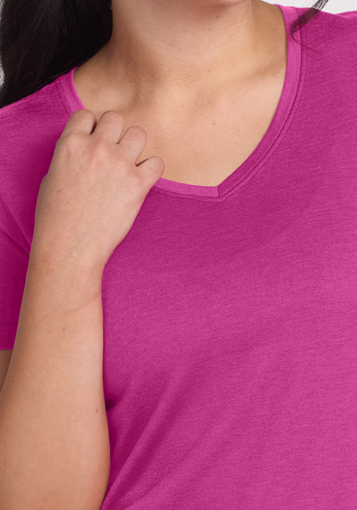 Woman in a Woolx Junie V Neck - Summer Sorbet tee with a relaxed fit, holding the collar with her left hand.