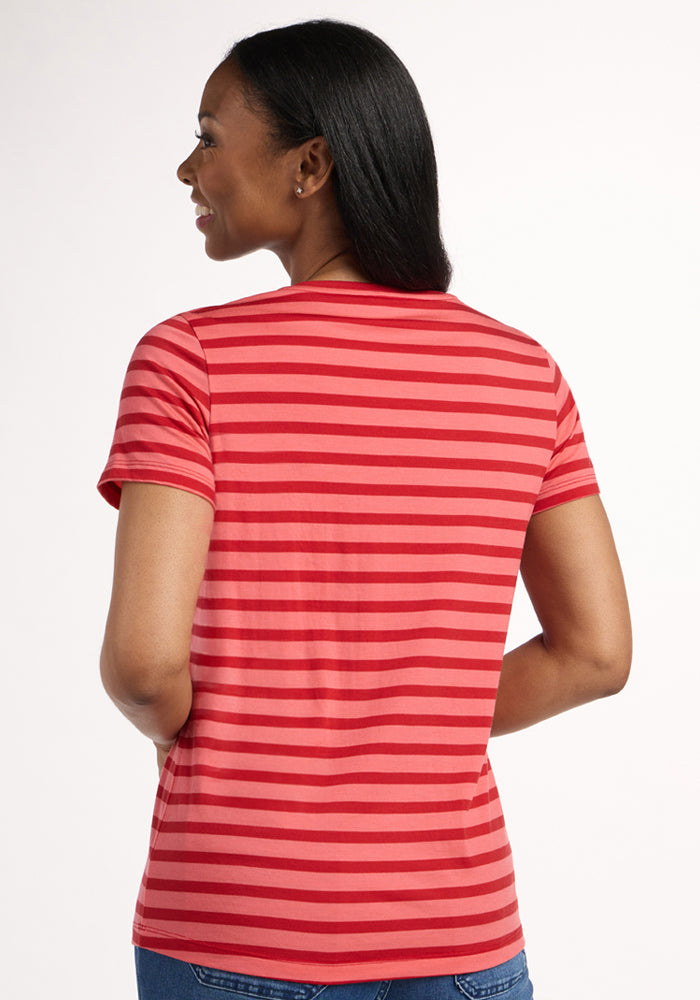 A woman with straight dark hair is seen from the back, wearing the Woolx Junie V Neck in Wildberry Stripe and blue jeans, standing against a plain light background.