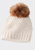 A chunky knit white beanie from Woolx, featuring a ribbed brim and a large brown faux fur pom-pom on top.