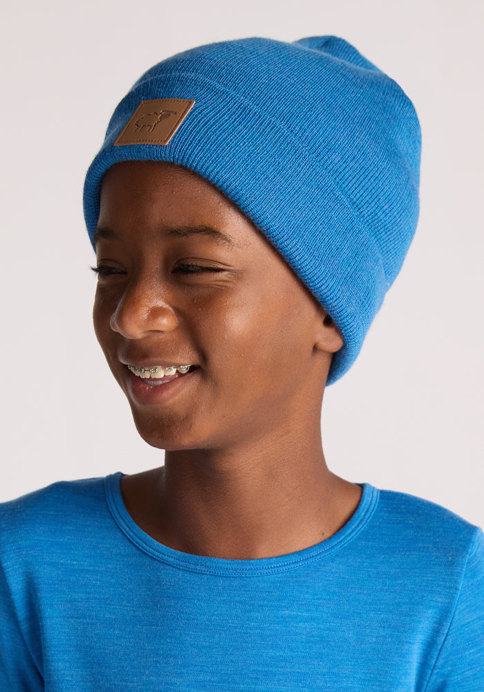 A toddler wearing the Woolx Kids Baylor Beanie in Blue Razz.