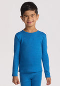 A young boy with short dark hair smiles and stands facing forward, wearing the Woolx Kids Explorer Base Layer Top in Blue Razz against a plain white background. | Leo is wearing a size XSM.