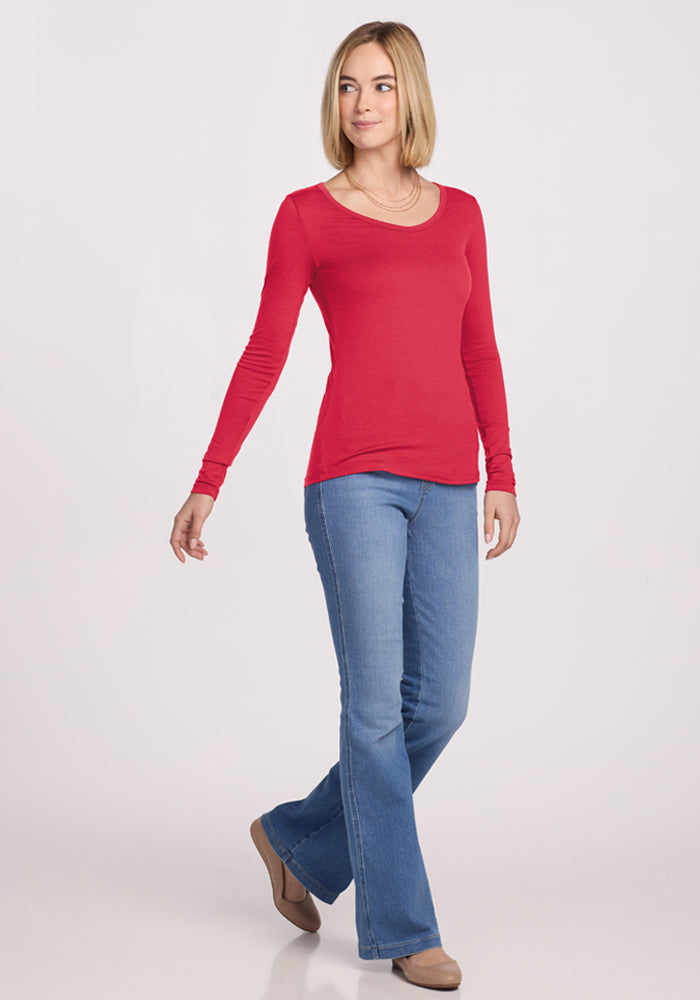 Woman wearing Woolx Layla V Neck Top - Berry Ice Pop, blue jeans, and brown shoes, walking and smiling.