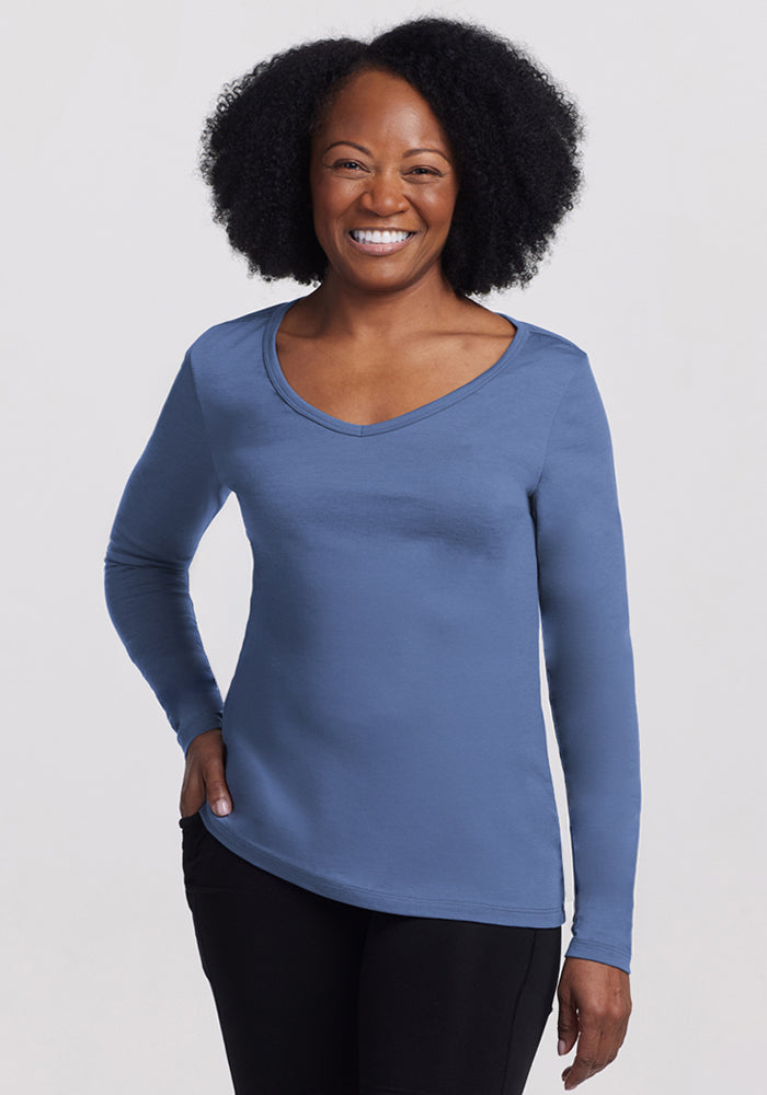 Smiling woman in Woolx Layla V Neck Top in Skyline, standing against a plain background, final sale.