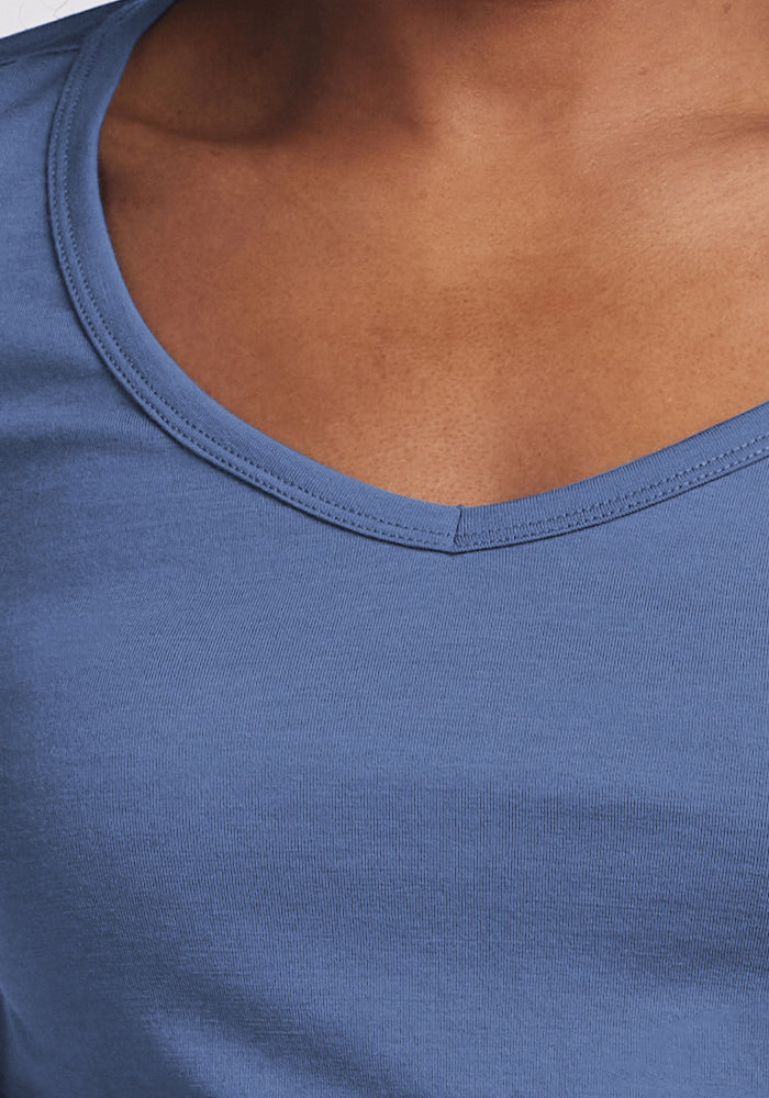 Close-up of a person wearing the Woolx Layla V Neck Top in Skyline, highlighting the neckline and shoulder.