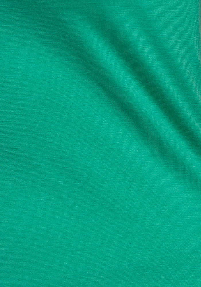 Soft green Layla V Neck Top by Woolx, fine knit texture—perfect as a stylish merino travel shirt.