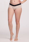 A person models the Woolx Lila Boy Shorts in Cream Heather, with a snug fit and black waistband for all-day comfort. One leg is bent, and arms are partially visible against a white background.