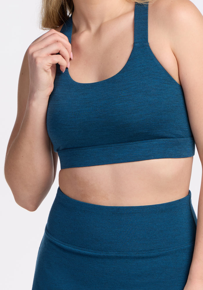 Woman wearing the Woolx Livi Bra in Majolica Blue, posing against a plain background.