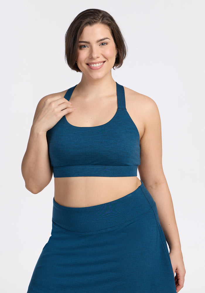 Woman smiles in Woolx Livi Bra • Final Sale - Majolica Blue, posing against a plain white background.
