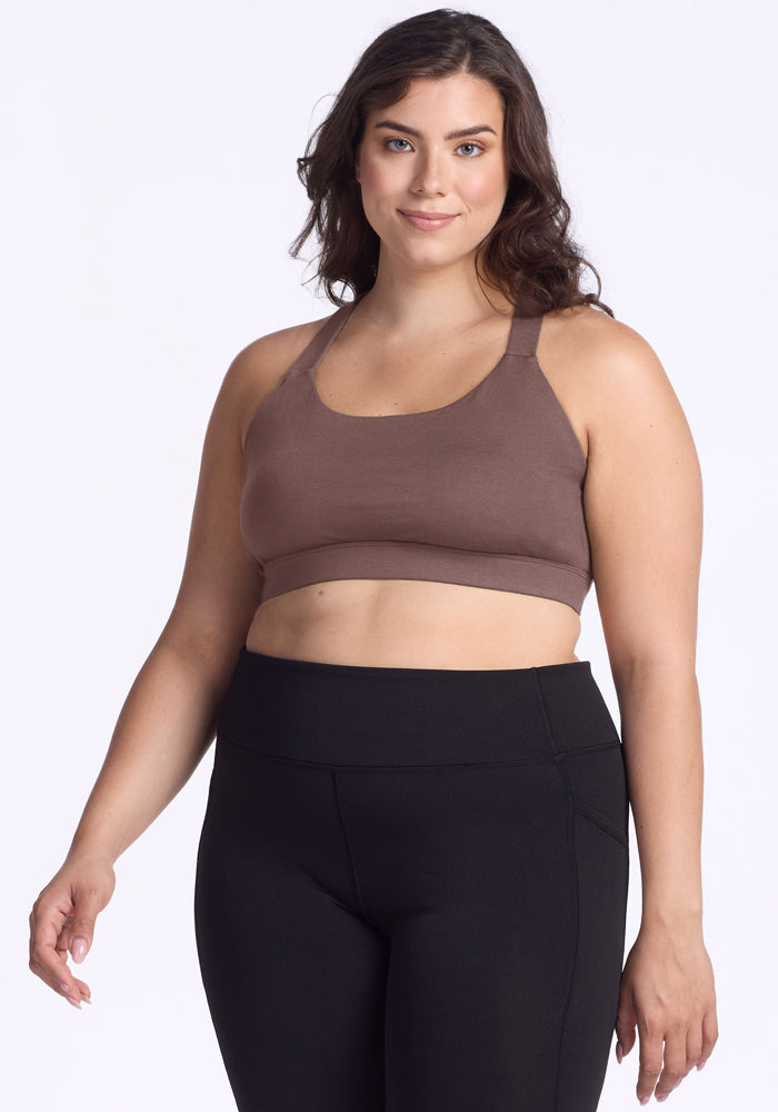 Woman wearing the Woolx Livi Bra in Peppercorn and black leggings, smiling against a plain white background. | Juliana is 5'10", wearing a size XL