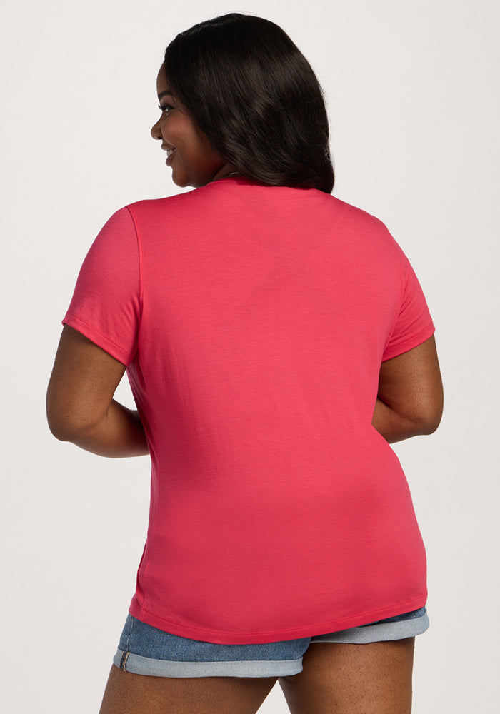 Woman with long dark hair wears the Woolx Liza Crew Neck Tee in Berry Ice Pop and denim shorts, shown from the back.