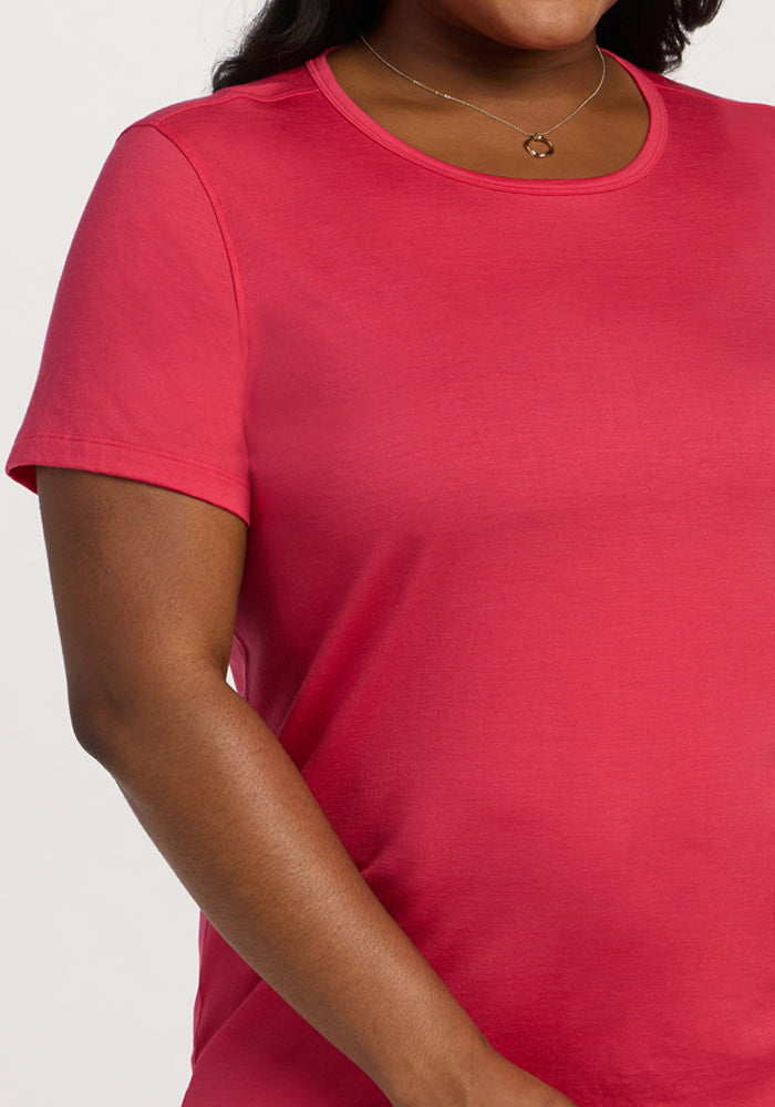 A person wearing the Woolx Liza Crew Neck Tee in Berry Ice Pop and a delicate necklace with a small pendant.