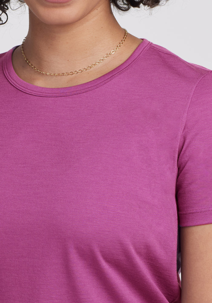 A person wears a gold chain and the Woolx Liza Crew Neck Tee in Purple Wine, shown from shoulders to chin.
