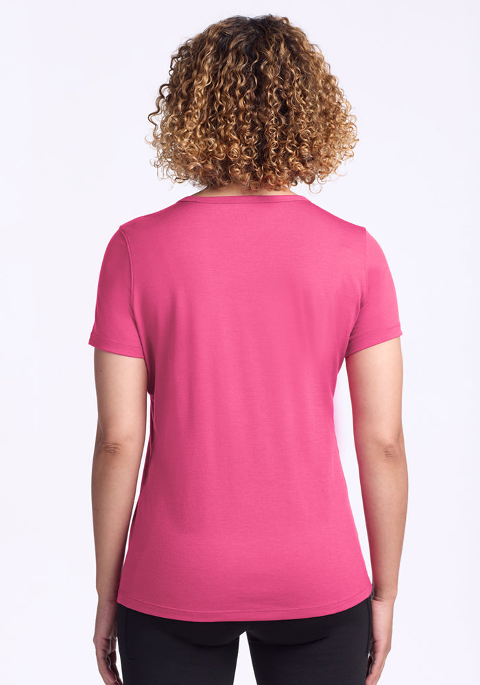Person with curly hair seen from the back wearing Woolx Liza Crew Neck Tee in Raspberry Fizz against a white background.