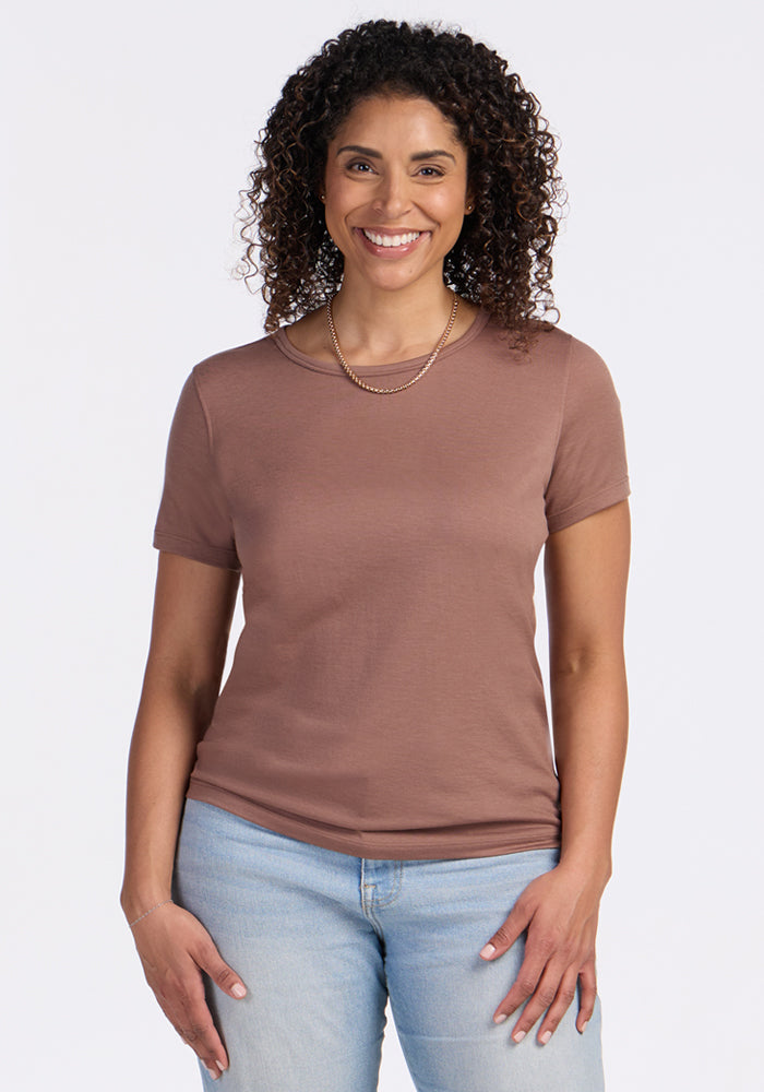 Smiling woman in Woolx Liza Crew Neck Tee • Final Sale - Sienna Kiss and jeans, standing against a white background.