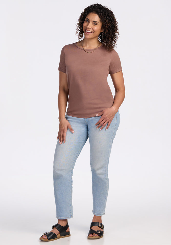 Smiling woman with curly hair wears the Woolx Liza Crew Neck Tee in Sienna Kiss on a white background.