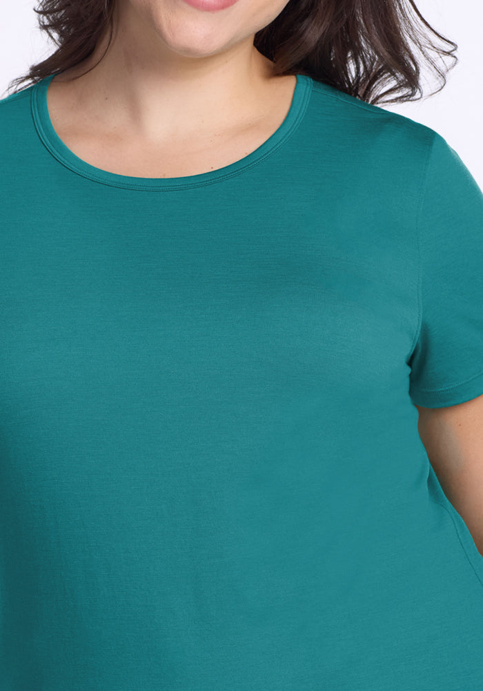 Woman models the Woolx Liza Crew Neck Tee in Surfside, shown from shoulders to upper torso with a slight smile.