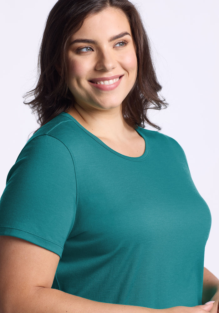 Woman with shoulder-length brown hair wears the Woolx Liza Crew Neck Tee in Surfside, smiling against a light background.