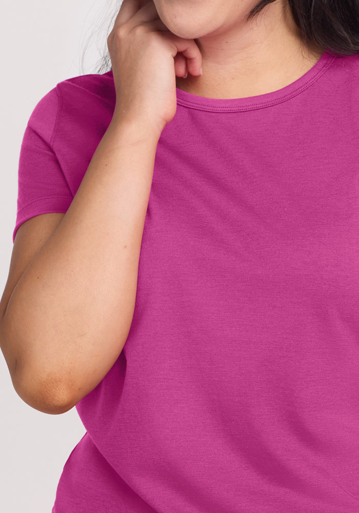 A woman wears the Woolx Liza Crew Neck Tee in Summer Sorbet, touching her face from shoulders to mouth.