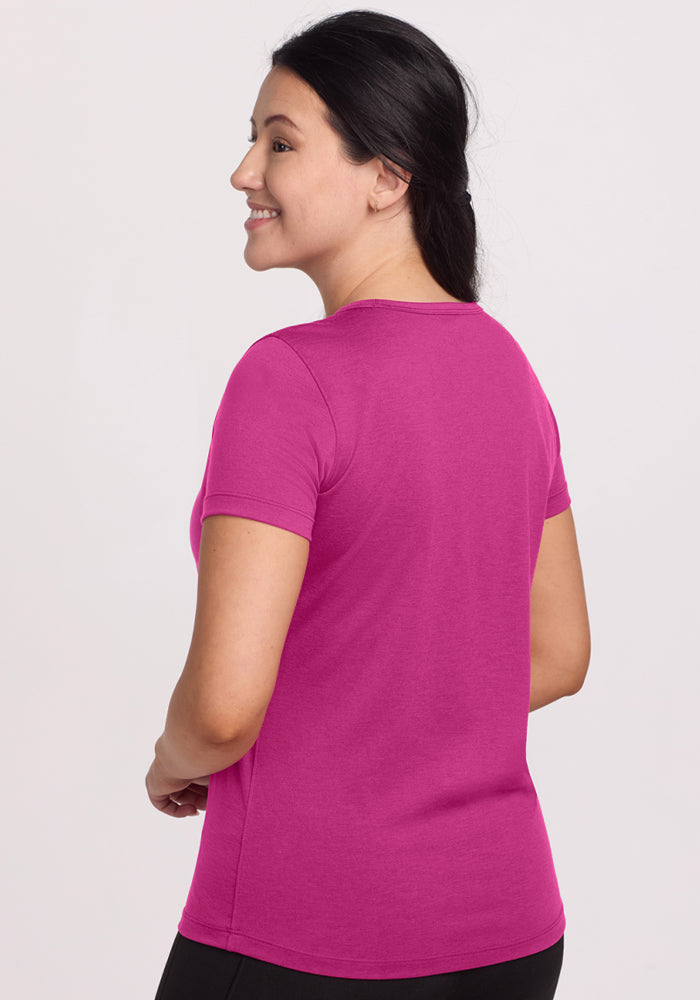 Woman with dark hair in a ponytail, smiling in Woolx Liza Crew Neck Tee - Summer Sorbet, facing away.