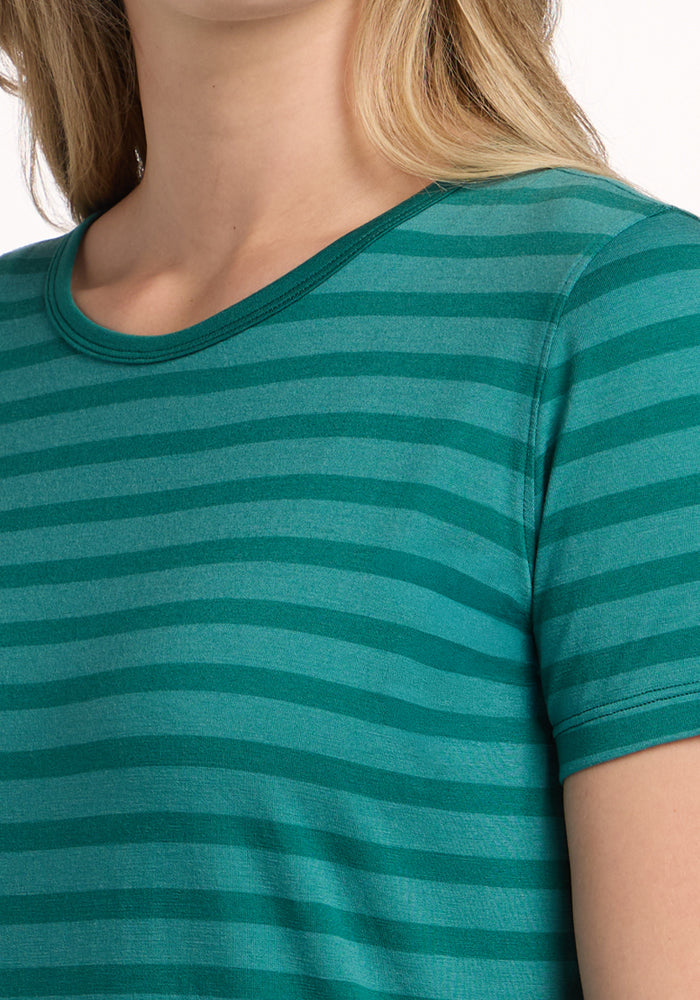A person wears the Woolx Liza Crew Neck Tee in Woodland Stripe, shown from shoulders to chest.