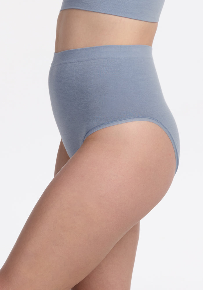 A person wearing Woolx Mabel Full Coverage Underwear in Bluebell with a matching top, shown from the side against a plain white background.