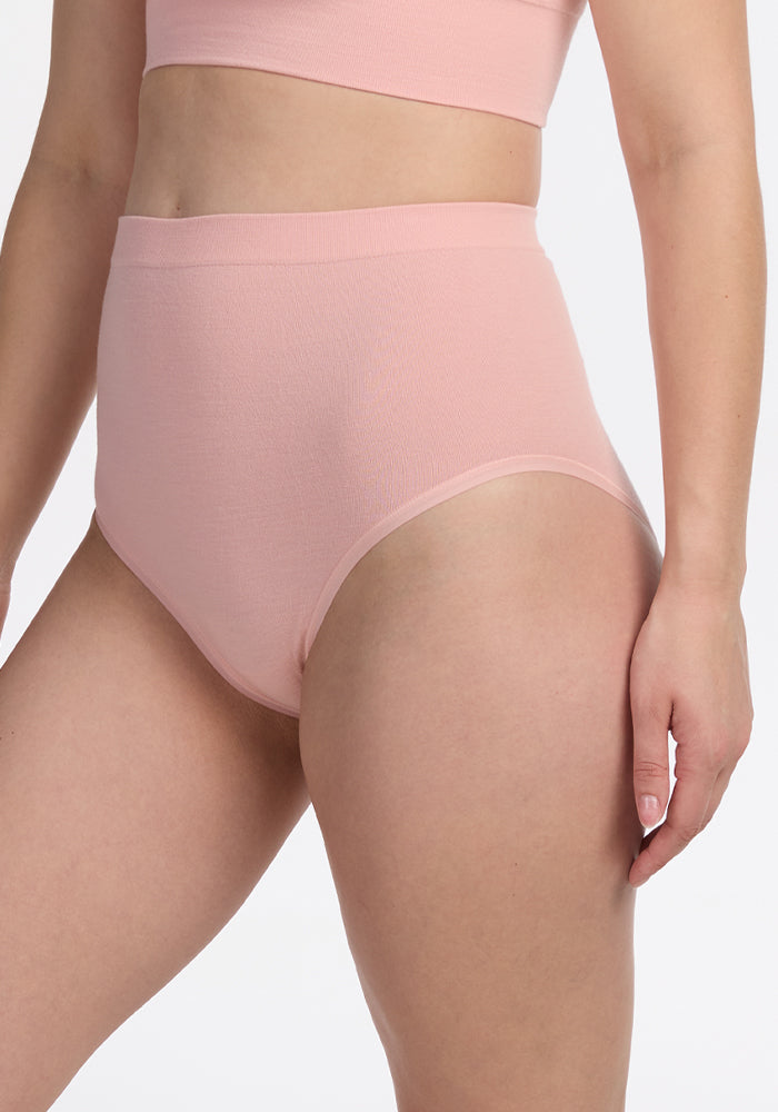 A person is shown from mid-torso to mid-thigh wearing Woolx's Mabel Full Coverage Underwear in Rosewater, against a plain white background.