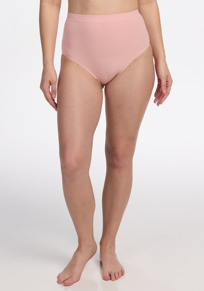 A person stands barefoot against a white background, modeling Woolx Mabel Full Coverage Underwear in Rosewater, with only their body from the chest down to the feet visible.