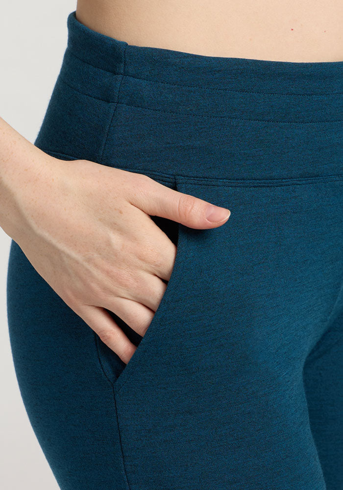 A person wearing Woolx Madden Joggers - Majolica Blue puts their right hand in the joggers' side pocket.