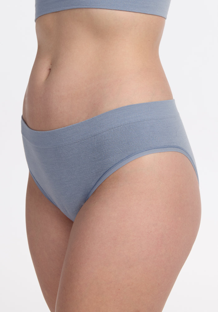 A person is shown from chest to upper thigh wearing the Woolx Maeve Bikini - Bluebell set, standing against a plain white background.