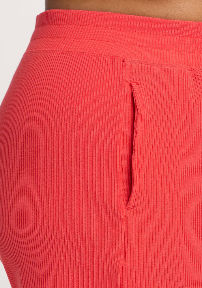 Close-up of a person wearing Woolx Maisey Ribbed Shorts in Hibiscus, featuring a side pocket.