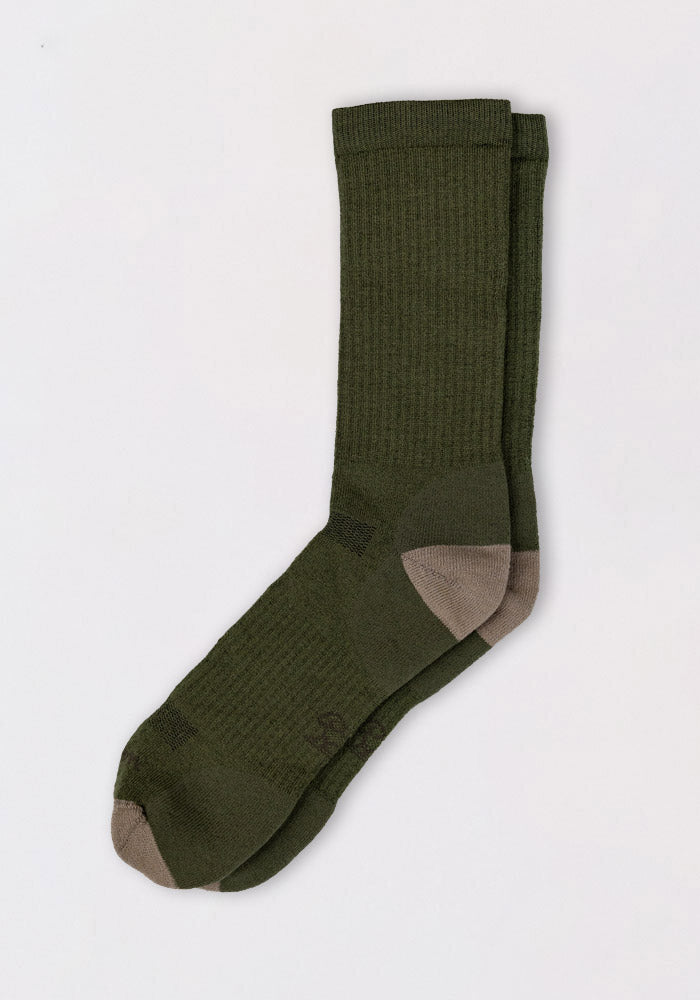 A pair of Woolx Mens Core Crew Socks in Winter Moss with cushioned green fabric, ribbed cuffs, and contrasting gray toes and heels, laid flat on a white background.