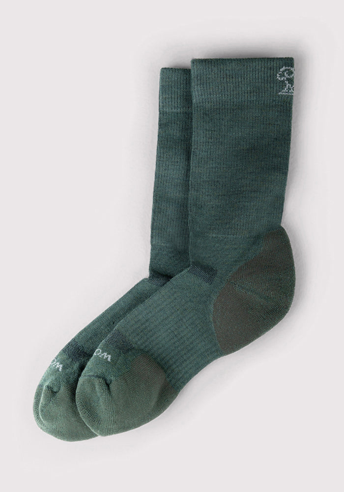 The Woolx Mens Harbor Crew Sock in Forest features moisture-wicking, breathable fabric and reinforced heel and toe areas. Subtle branding appears near the top of one sock, and they're displayed on a light background.