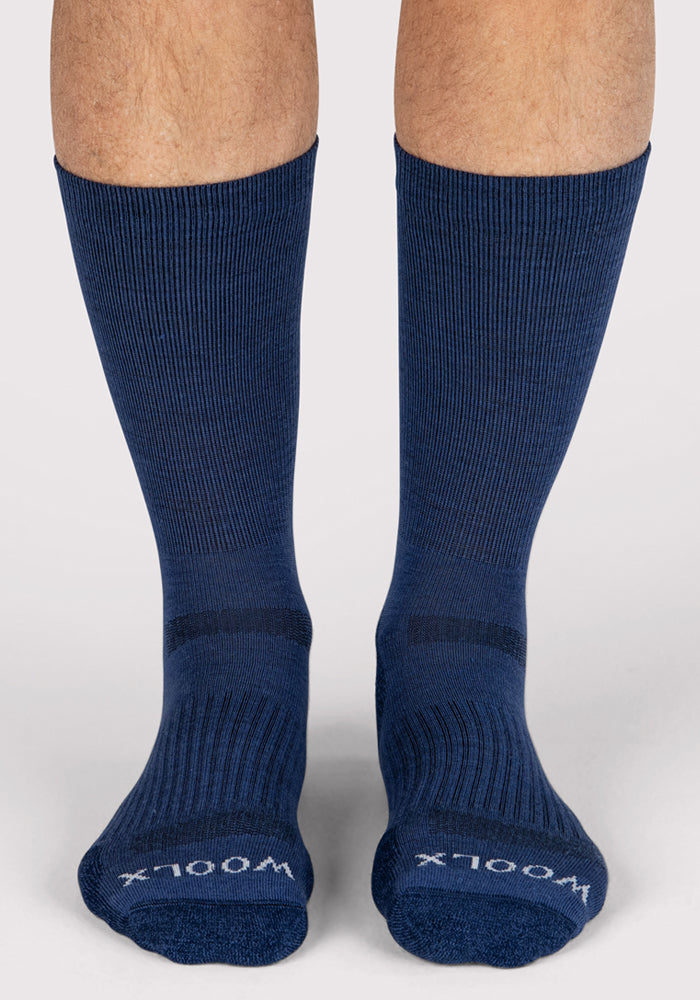A pair of feet wearing Woolx Mens Harbor Crew Socks in Sailor Blue, featuring a ribbed crew design and "WOOLX" in white on the toes, shown from the front against a light background.