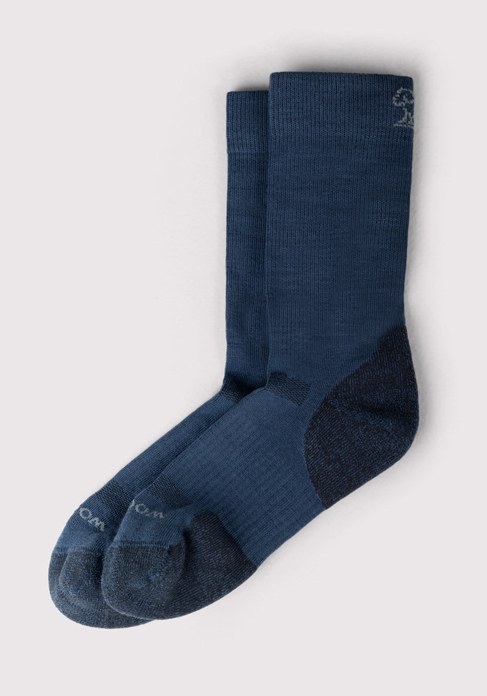 The Woolx Mens Harbor Crew Sock in Majolica Blue is shown side by side on a light background, featuring moisture-wicking fabric, reinforced heels and toes, and subtle logo detailing near the cuff.