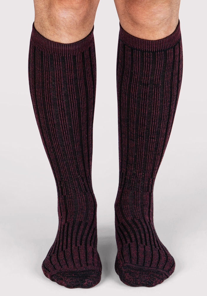 A front view of legs wearing Woolx Mens Joey Mid Calf Socks in Warm Violet, featuring ribbed Merino wool with black and dark burgundy stripes, against a plain white background.
