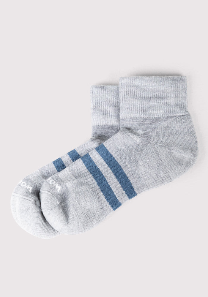 The Woolx Mens Rambler Ankle Sock in grey features moisture-wicking fabric and two horizontal blue stripes near the cuff, shown on a plain light background.