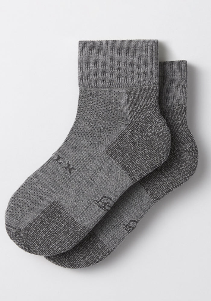 The Woolx Mens Rambler Ankle Sock - Pebble features ribbed cuffs, textured knit, and subtle black sole lettering. Shown overlapping on a light background—ideal moisture-wicking socks for all-day comfort.