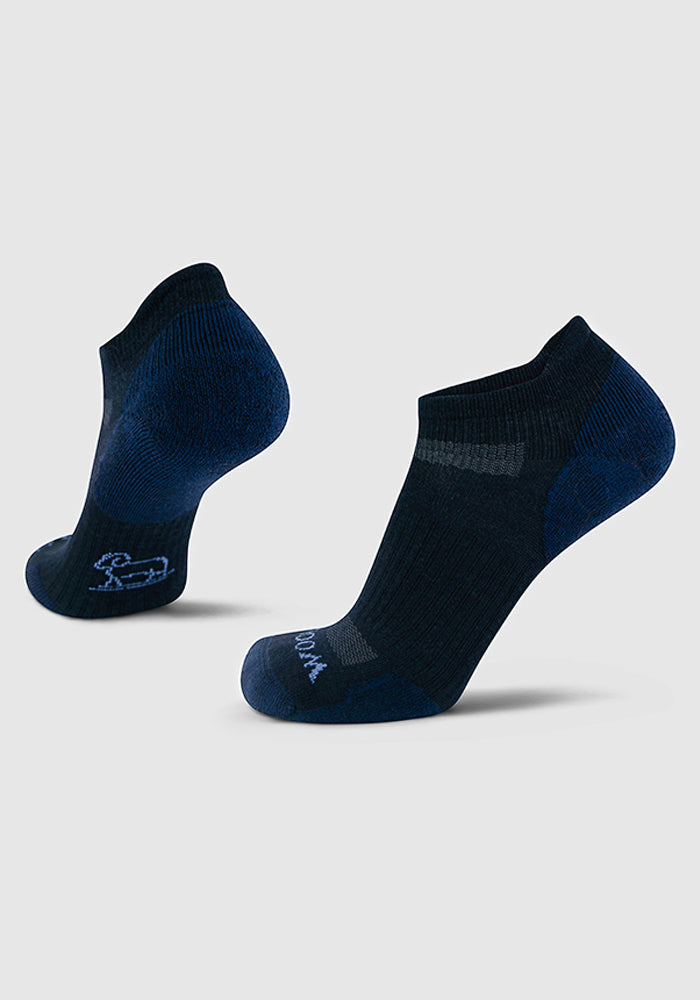 Woolx Mens Rowan No Show Socks in Deep Night are shown on a light gray background, with one upright and one angled to display the heel and footbed. These Merino wool socks appear soft, cushioned, and feature subtle textured patterns.