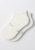 A pair of Woolx Mens Rowan No Show Socks in White Lightning, featuring cushioned soles with subtle gray lettering, displayed flat on a white background.