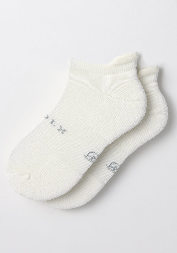 A pair of Woolx Mens Rowan No Show Socks in White Lightning, featuring cushioned soles with subtle gray lettering, displayed flat on a white background.