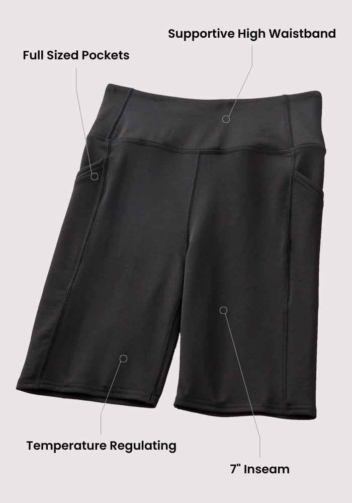 The Woolx Merino Flex® Dani Bike Shorts - Everleaf feature a high waistband, moisture-wicking merino fabric, full-sized side pockets, 7-inch inseam, and temperature-regulating design. Labels highlight each feature on the shorts.