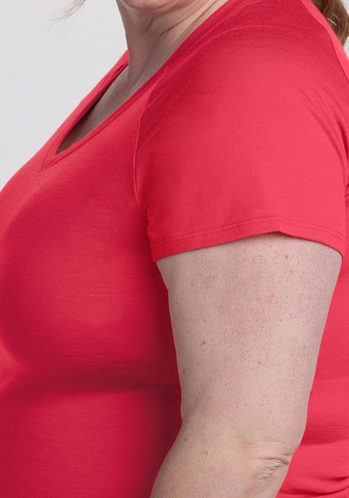 A woman wears the Woolx Mia V Neck - Berry Ice Pop, shown from shoulders to mid-arm on a light background.
