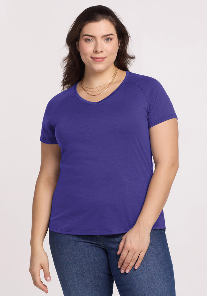 Smiling woman in Woolx Mia V Neck - Berry Indigo tee and jeans, facing the camera against a plain background. | Juliana is 5'10", wearing a size XL