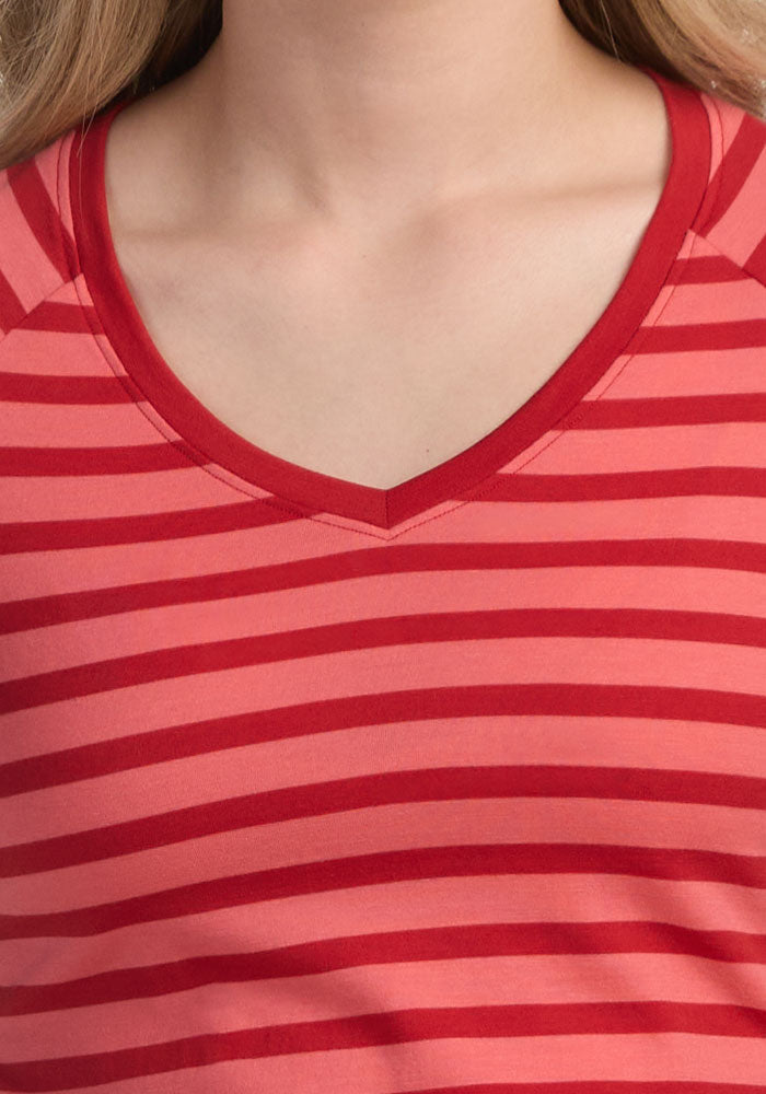 A close-up shows a person wearing the Woolx Mia V Neck tee in Wildberry Stripe, highlighting the lightweight, odor-resistant Merino wool fabric on the upper chest, neck, and part of the shoulders.