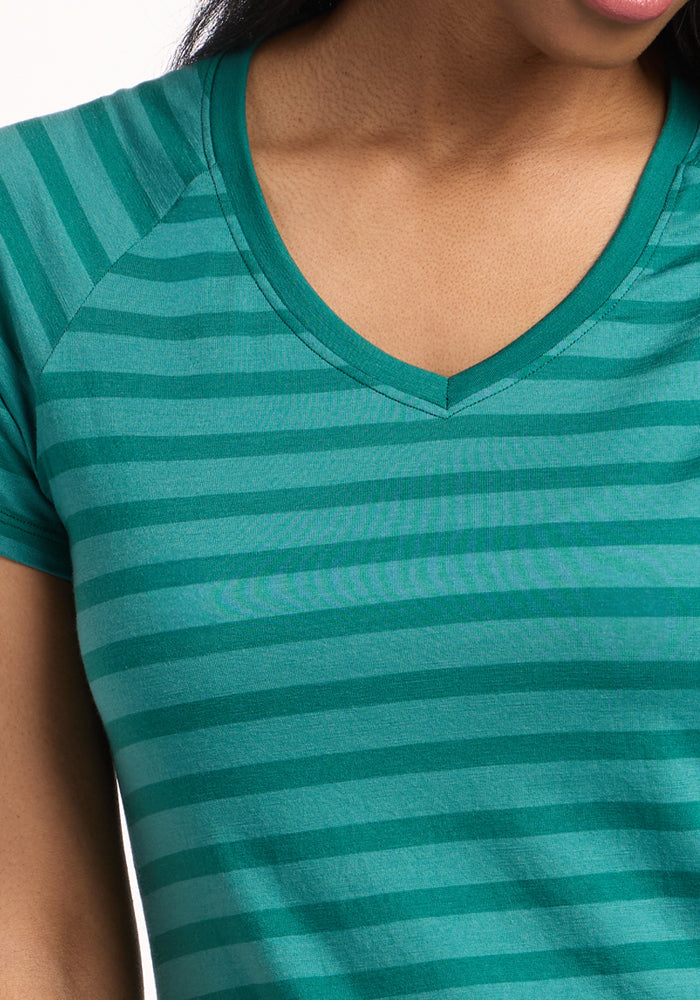 Close-up of a person wearing the Woolx Mia V Neck in Woodland Stripe. The soft, odor-resistant Merino wool women’s tee is shown on the upper torso, arm, neck, and lower face.