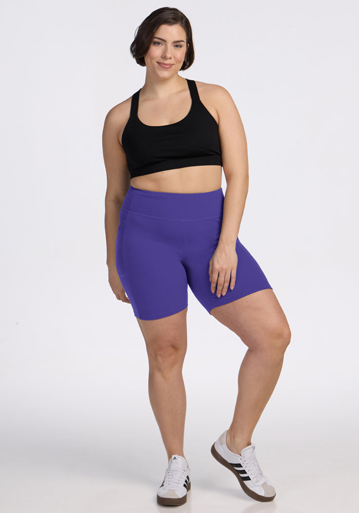 Woman in Miley Bike Shorts - Berry Indigo by Woolx poses confidently against a plain white background.