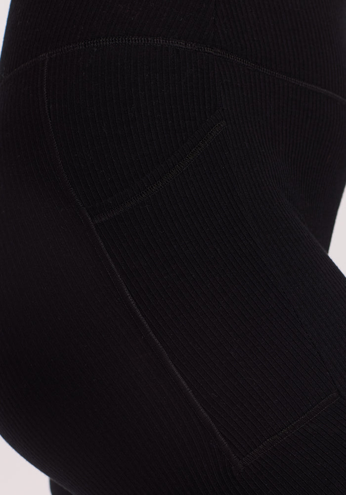 Close-up of a person wearing Woolx's Miley Bike Shorts in black, showcasing visible side seams and a pocket. The ribbed texture highlights the snug fit against a plain background.