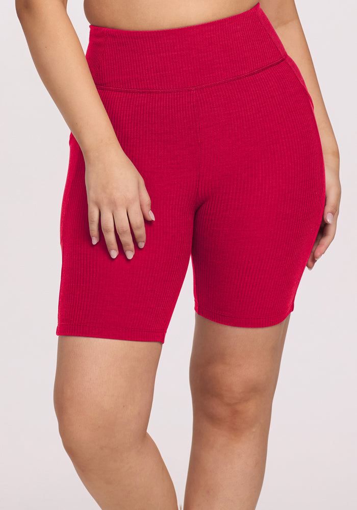 Model in Woolx Miley Bike Shorts • Final Sale - Poppy Spark, hand on thigh, against a plain background.